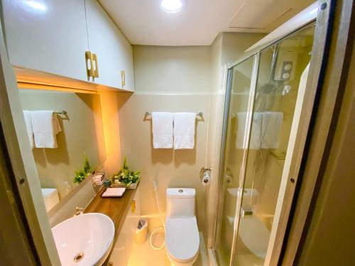 a bathroom with a toilet and a sink and a shower at FameStaycation at FAME Residences in Manila