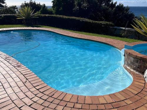 a large swimming pool with a brick pathway around it at Waves of Mercy in Trafalgar