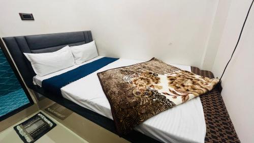 a small bedroom with a bed with a blanket on it at Neelkanth pg house in Varanasi