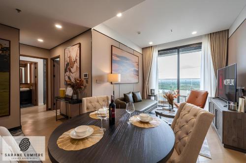 a living room with a dining table and a living room at Sarene Lumiere Riverside Thao Dien in Ho Chi Minh City