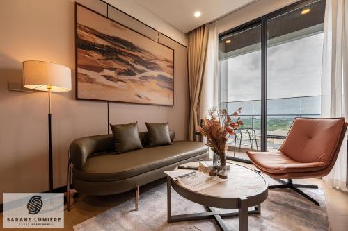 a living room with a leather couch and a table at Sarene Lumiere Riverside Thao Dien in Ho Chi Minh City