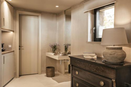 a bathroom with a table with a lamp and a sink at F ZEEN Kefalonia in Lourdhata