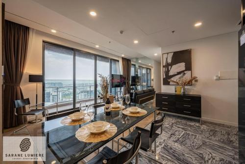 a dining room with a glass table and chairs at Sarene Lumiere Riverside Thao Dien in Ho Chi Minh City