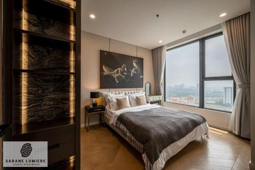 a bedroom with a large bed and a large window at Sarene Lumiere Riverside Thao Dien in Ho Chi Minh City