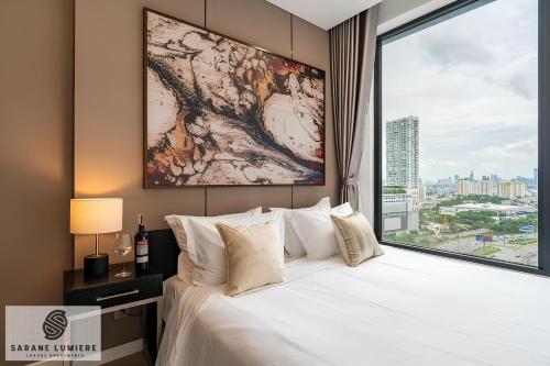 a bedroom with a large bed with a large window at Sarene Lumiere Riverside Thao Dien in Ho Chi Minh City