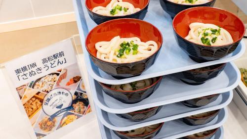 a refrigerator filled with bowls of food on a shelf at Toyoko Inn Takamatsu Ekimae in Takamatsu