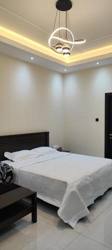 ein Schlafzimmer mit einem großen Bett und einem Kronleuchter in der Unterkunft Villa 6 in Ajman 