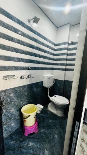 a bathroom with a toilet and a bucket in it at Neelkanth pg house in Varanasi