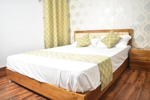 a bedroom with a bed with white sheets and pillows at Hasimara River View Home Stay in Hāsimāra