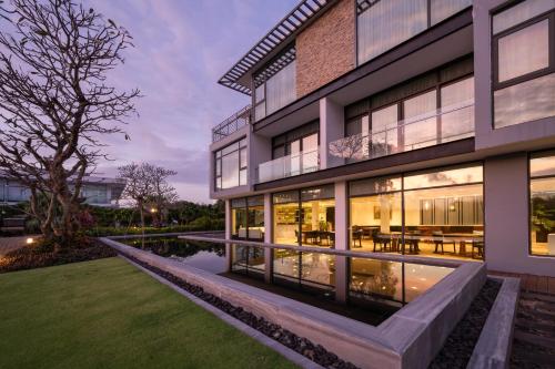 a building with a pond in front of it at Montgomerie Links Hotel & Villas in Hoi An