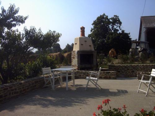 a table and chairs in front of a brick oven at Marie France 's home in Sacey