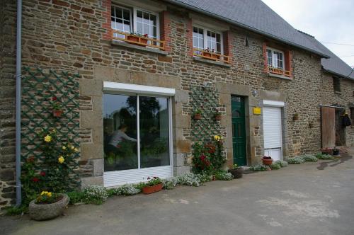 a brick building with a window and flowers on it at Marie France 's home in Sacey