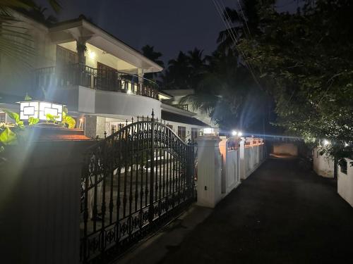 una cerca frente a una casa por la noche en Pinky's Villa, en Trivandrum
