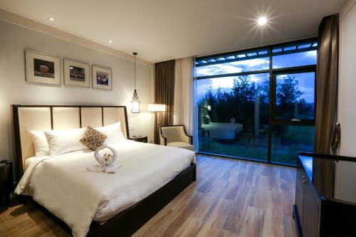 a bedroom with a bed with a stuffed animal on it at Montgomerie Links Hotel & Villas in Hoi An