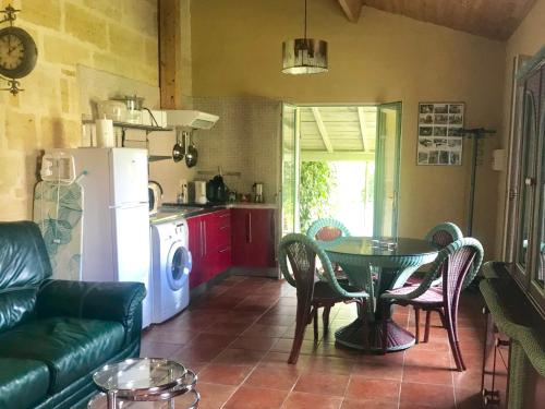 un salon avec une table et une cuisine dans l'établissement Gites face rivière Saint-Emilion, à Vignonet