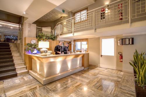 two men standing at a bar in a lobby at Hotel Delle Nazioni in Florence
