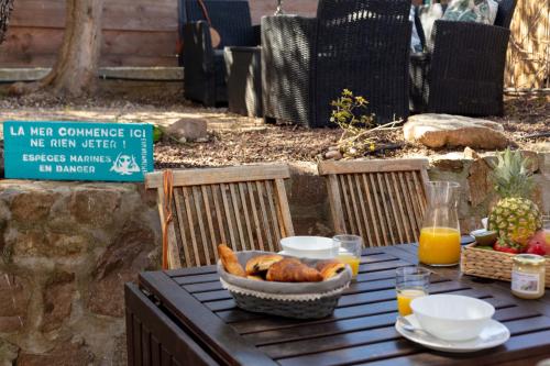 - une table avec un bol de pain et du jus d'orange dans l'établissement La Janette, charmante villa pour 6-8 pers avec une situation idéale, proche des plages et du sentier du littoral, à Hyères