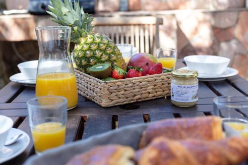 - une table avec une corbeille de fruits et de jus d'orange dans l'établissement La Janette, charmante villa pour 6-8 pers avec une situation idéale, proche des plages et du sentier du littoral, à Hyères