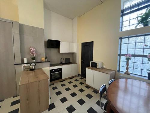 une cuisine avec une table et un comptoir dans l'établissement F1 bis Centre Cambrai, à Cambrai