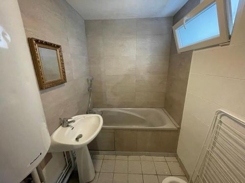 une salle de bain avec un lavabo et une baignoire dans l'établissement F1 bis Centre Cambrai, à Cambrai