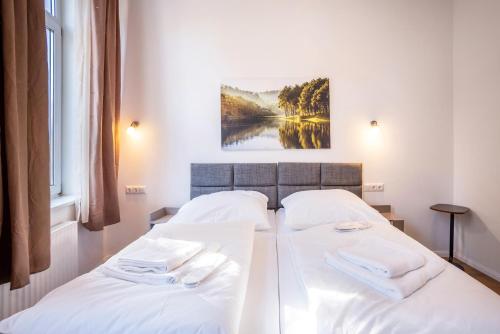 two beds in a hotel room with white sheets at Altstadt Residenz in Lübeck