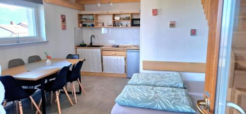 a kitchen and dining room with a table and a bed at Apartments Štrancar wines in Ajdovščina
