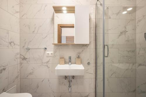 a white bathroom with a sink and a shower at Altstadt Residenz in Lübeck