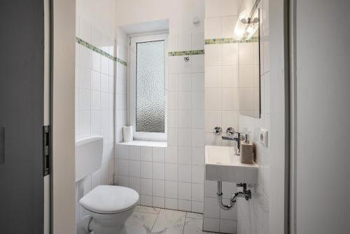 a white bathroom with a toilet and a sink at Altstadt Residenz in Lübeck