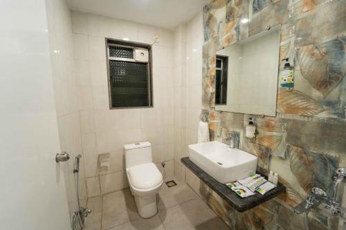 a bathroom with a toilet and a sink and a mirror at Treebo Winter Town Venna Lake in Mahabaleshwar