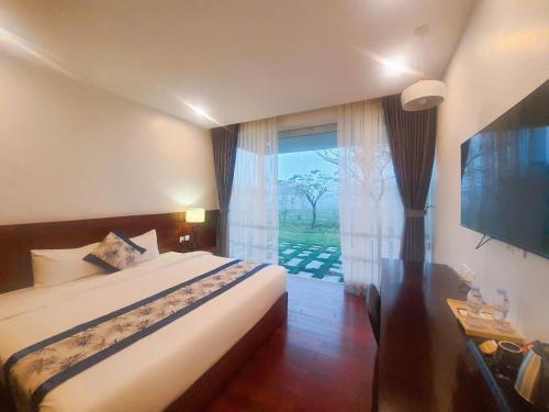 Un dormitorio con una cama y una ventana grande. en Villas Vedana Cuc Phuong, en Thượng Sung