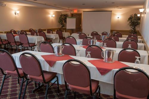 a conference room with tables and chairs and a screen at Jiminy Peak Mountain Resort in Hancock