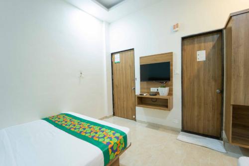 a bedroom with a bed and a tv in it at Treebo Winter Town Venna Lake in Mahabaleshwar