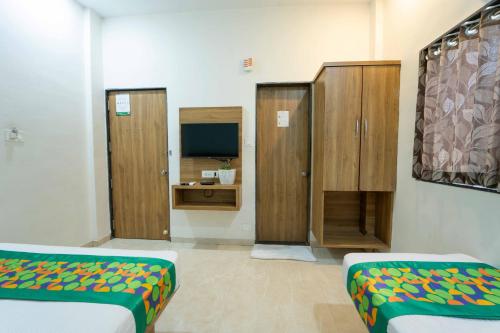 a room with two beds and wooden cabinets at Treebo Winter Town Venna Lake in Mahabaleshwar