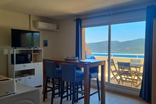 Il dispose d'un balcon et d'une cuisine avec une table et des chaises. dans l'établissement T2 vue mer clim dans résidence 3 piscine chauffée saison & plage à pied, à Serra-di-Ferro