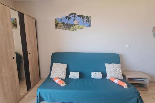 - une chambre avec un lit bleu et des oreillers dans l'établissement T2 vue mer clim dans résidence 3 piscine chauffée saison & plage à pied, à Serra-di-Ferro