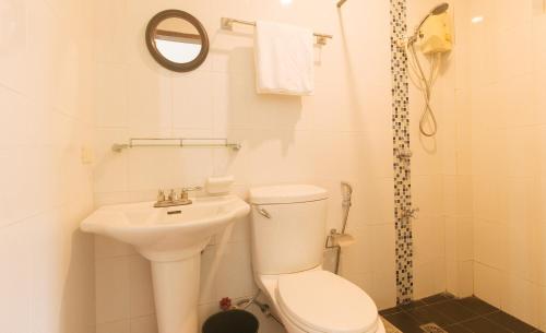 a white bathroom with a toilet and a sink at RedDoorz at Garvs Boutique Hotel Boracay in Boracay