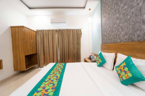 a bedroom with a large white bed and a cabinet at Treebo Winter Town Venna Lake in Mahabaleshwar