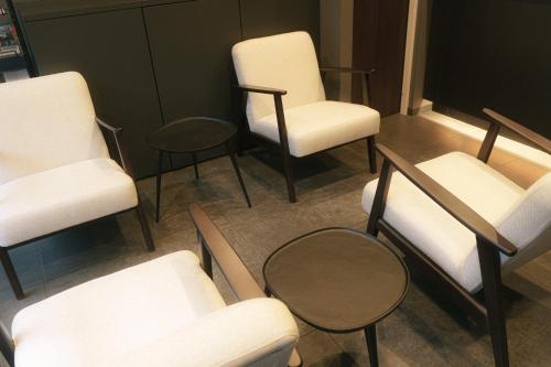 un grupo de sillas y mesas en una habitación en INOVA Kanazawa, en Kanazawa
