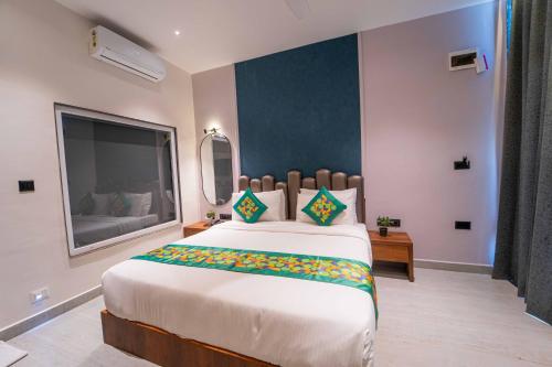 a bedroom with a large bed with a large window at Treebo Winter Town Venna Lake in Mahabaleshwar