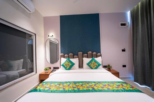 a bedroom with a large bed and a large window at Treebo Winter Town Venna Lake in Mahabaleshwar