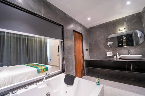 a bathroom with a bed and a sink and a tub at Treebo Winter Town Venna Lake in Mahabaleshwar