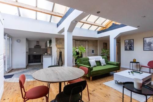 un salon avec un canapé vert et une table dans l'établissement Charmant Studio - Centre ancien, à Caen