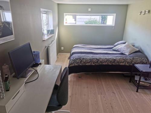 a bedroom with a bed and a desk with a television at Nice villa with sunny terrace, smaller pool jumping-pad in Stockholm