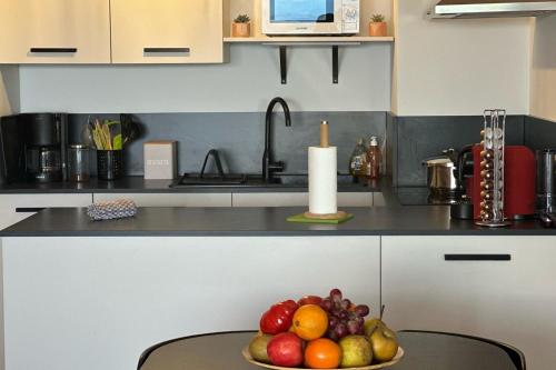 Un bol de fruta en una mesa de cocina. en T2 vue mer climatisé wifi & refait à neuf idéalement situé à Ajaccio, en Ajaccio