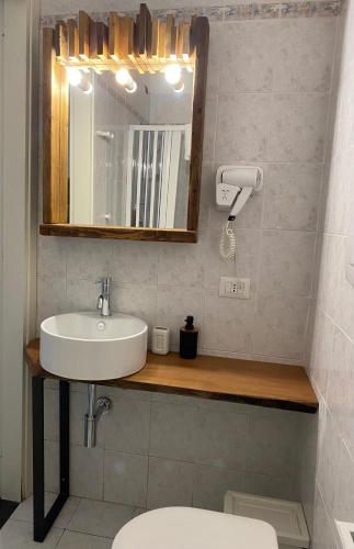 a bathroom with a sink and a mirror and a toilet at Black Market Hotel in Ischia