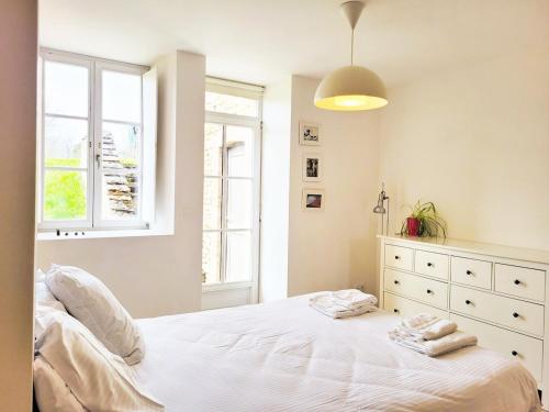 une chambre avec un lit blanc et une fenêtre dans l'établissement Cottage familial, grand jardin, toboggan, barbecue, à Beurizot