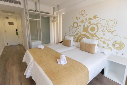 a bedroom with a large bed with two towels on it at BQ Cala Ratjada in Cala Ratjada