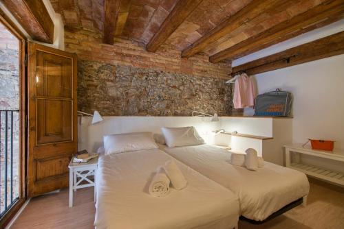 バルセロナにあるハッピー ピープル ランブラス ハーバー アパートメンツのレンガの壁、大きなベッド付きのベッドルーム1室