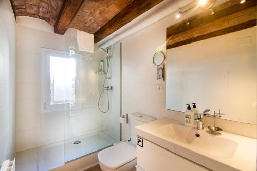 y baño con ducha, aseo y lavamanos. en Happy People Ramblas Harbour Apartments en Barcelona