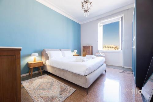 Un dormitorio azul con una cama y una ventana. en Beach, 2BR, Luxury Genoa, Wifi By Tilo, en Génova